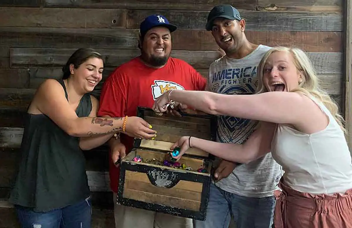 Group celebrating with treasure chest after an escape room